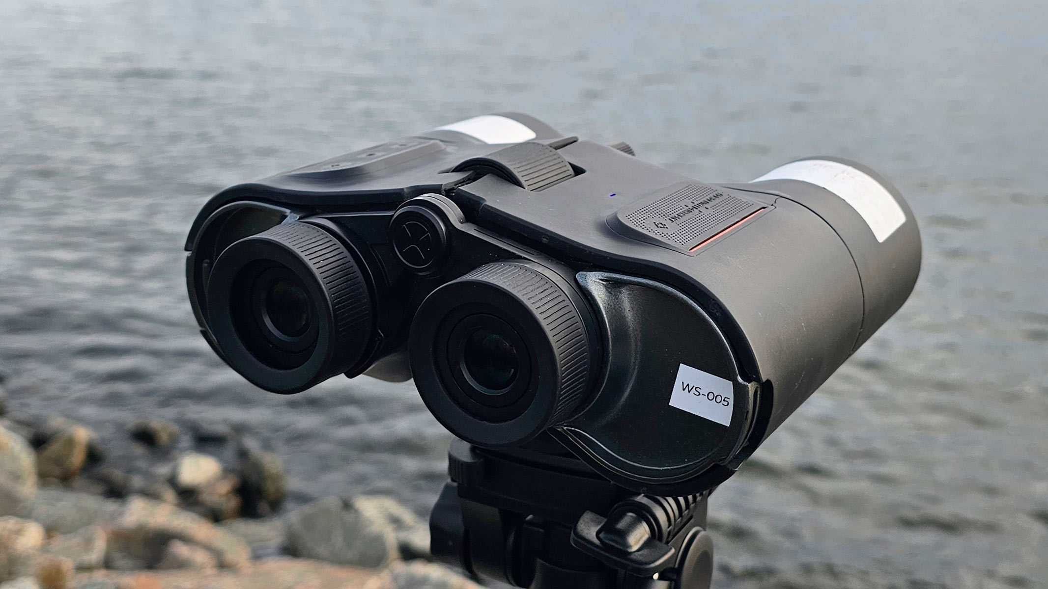A back view of the Unistellar Envision smart binoculars with water in the background.