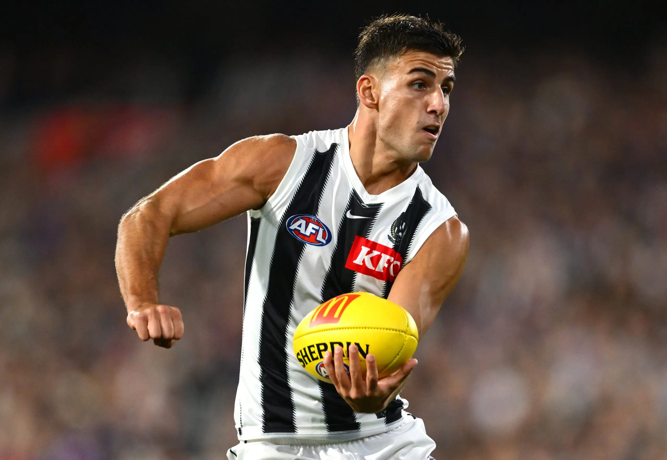 MELBOURNE, AUSTRALIA - MARCH 21: Nick Daicos of the Magpies handballs during the round two AFL match between Footscray Bulldogs (Western Bulldogs) and Collingwood Magpies at Melbourne Cricket Ground, on March 21, 2025, in Melbourne, Australia. (Photo by Quinn Rooney/Getty Images)
