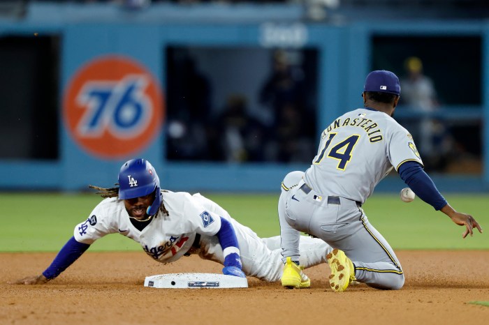 Justin Dean of the Los Angeles Dodgers steals a base in front of Andruw Monasterio
