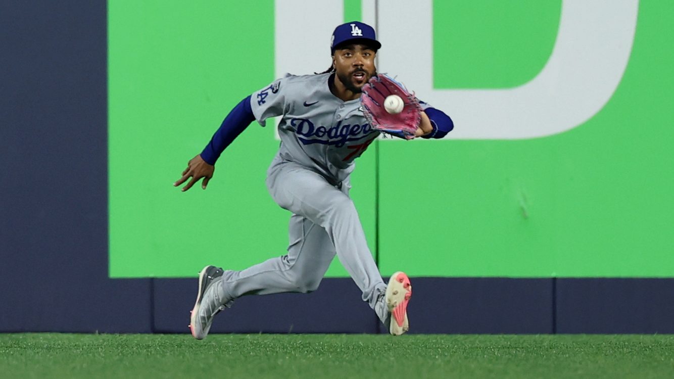 Los Angeles Dodgers outfielder Justin Dean fields the ball hit by Toronto Blue Jays' Alejandro Kirk during the ninth inning