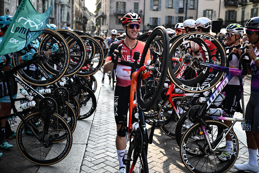 Ineos Grenadiers’s Italian rider Salvatore Puccio walks his bicycle past riders lining the start area to celebrate his last race ahead of the 119th edition of the Giro di Lombardia (Tour of Lombardy), a 238km cycling race from Como to Bergamo on October 11, 2025. (Photo by Marco BERTORELLO / AFP)