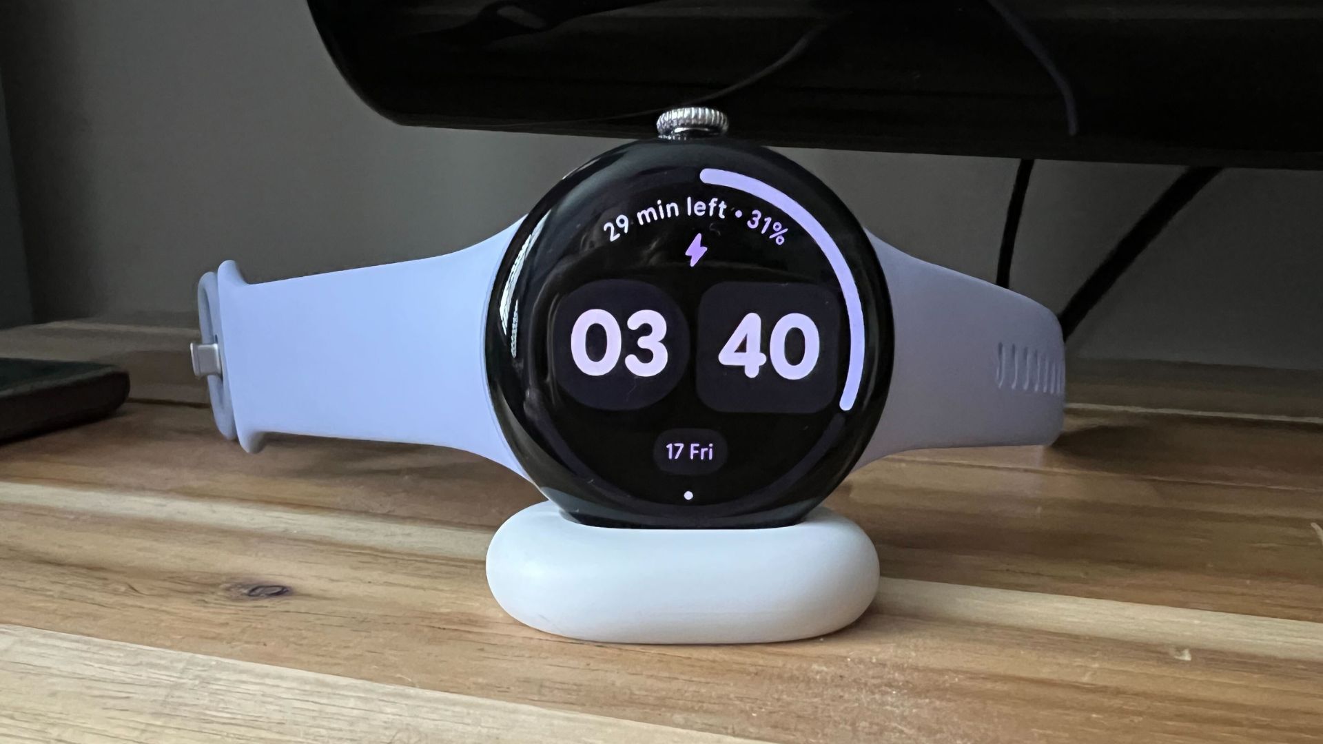 Grace Walsh's Google Pixel Watch 4 charging on mount on wooden counter