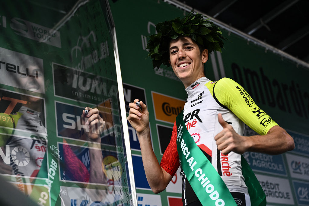 Intermarche–Wanty’s Italian rider Simone Petilli gives a thumbs up on the sign-in podium as he celebrates his last race, ahead of the 119th edition of the Giro di Lombardia (Tour of Lombardy), a 238km cycling race from Como to Bergamo on October 11, 2025. (Photo by Marco BERTORELLO / AFP)