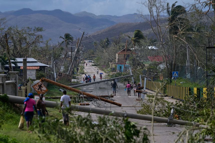 Residents walk through Lacovia Tombstone, Jamaica, in the aftermath of Hurricane Melissa, Wednesday.