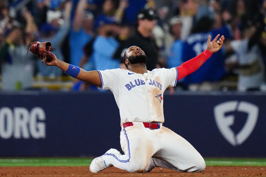 Vladimir Guerrero Jr. of the Toronto Blue Jays celebrates on his knees after winning Game 7 of the ALCS.