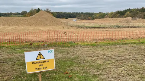 Tony Fisher/BBC A golf course under construction with a sign saying "keep out" in the foreground