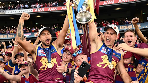 Callum Ah Chee and Brandon Starcevich of the Lions celebrate with the premiership cup.