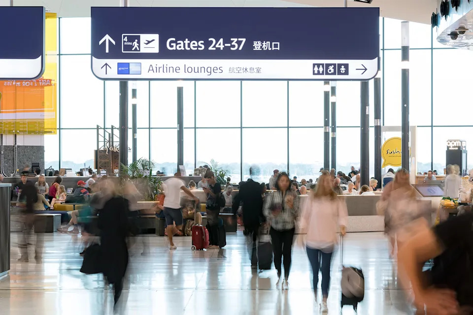 Passengers commute through a busy airport 
