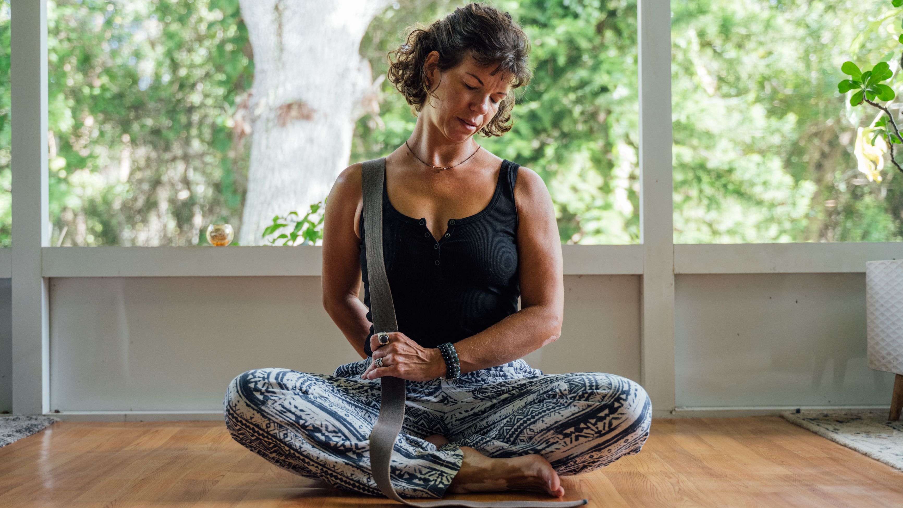 Woman lying on her back with the back of her head resting on a yoga block