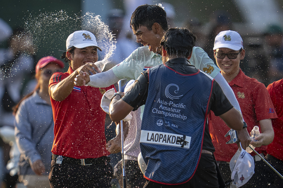 Fifa Laopakdee, center, celebrates after winning the 2025 Asia-Pacific Amateur Championship following a playoff at the Emirates Golf Club Majlis Course in Dubai, United Arab Emirates on Oct. 26.  [AAC]