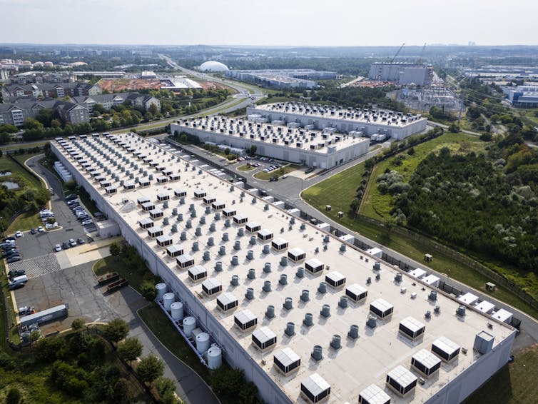 An aerial view of three large white buildings.