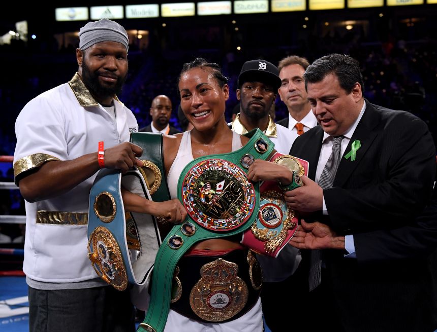 Cecilia Brækhus poses with her belts after a win over Kali Reis in 2018.
