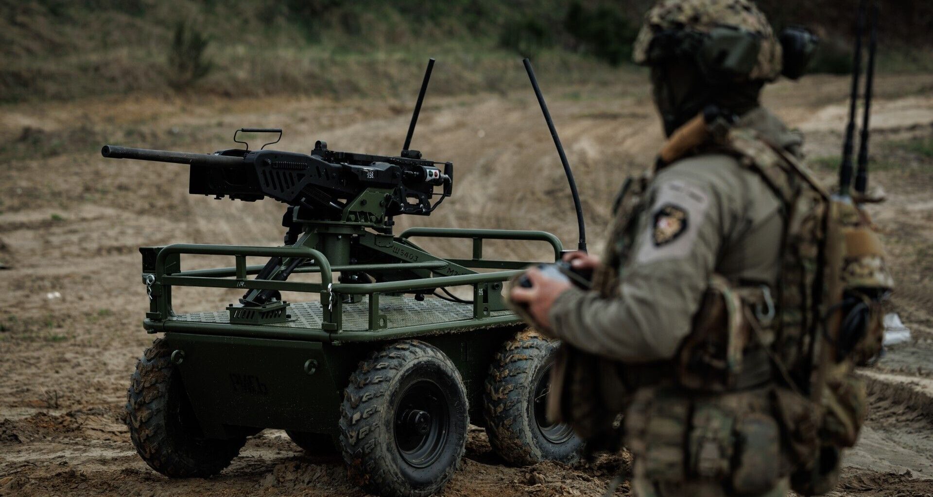 A soldier stands with a military robot in an undisclosed location