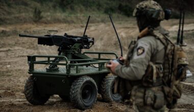 A soldier stands with a military robot in an undisclosed location