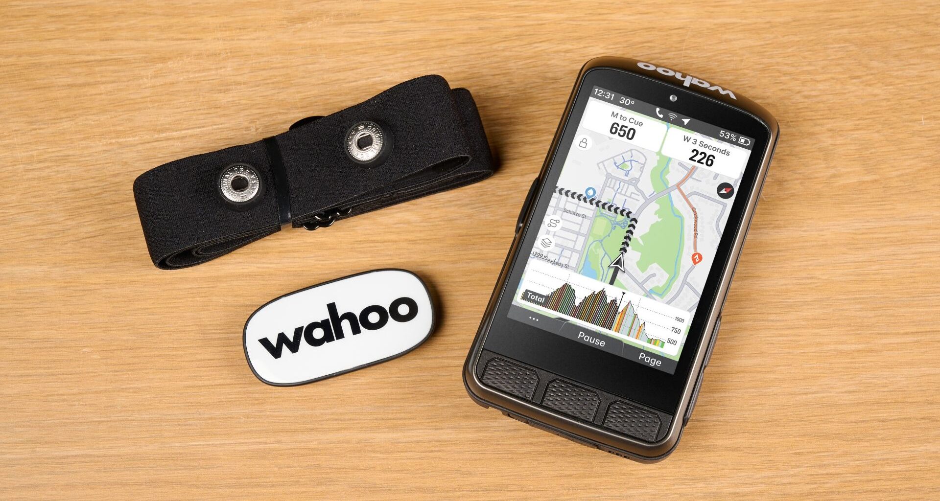 Wahoo Elemnt Ace with heart rate monitor on wooden backgorund