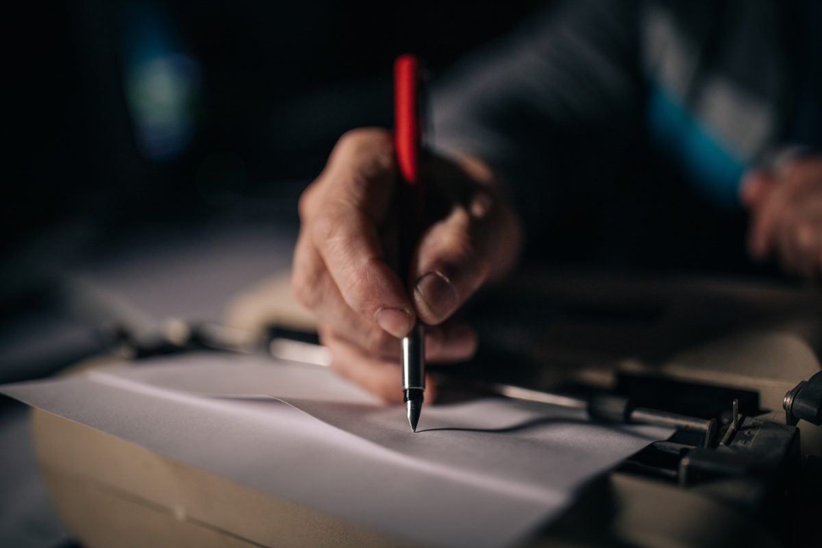 man's hand holding a pen