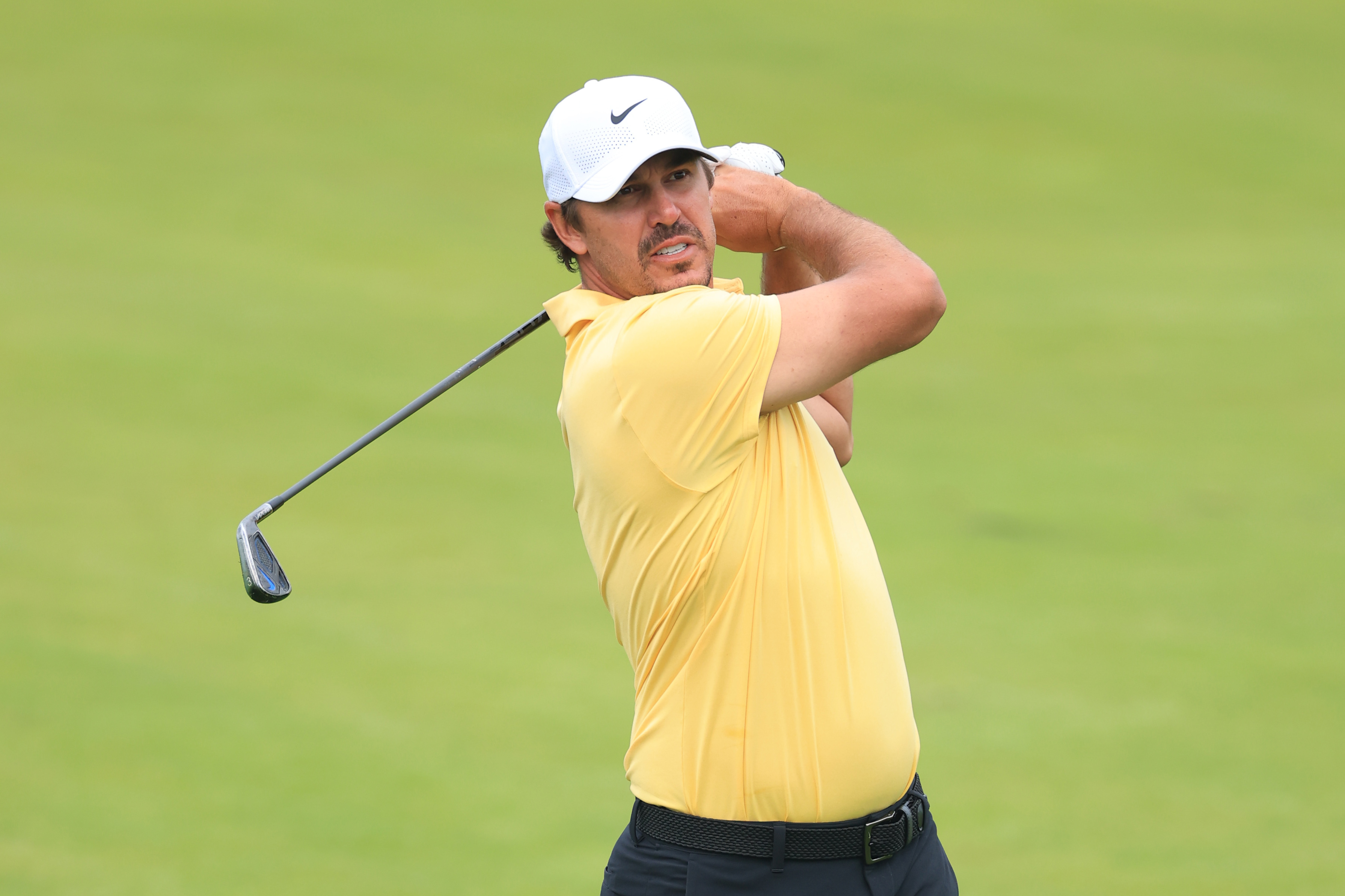 Brooks Koepka hits a utility iron