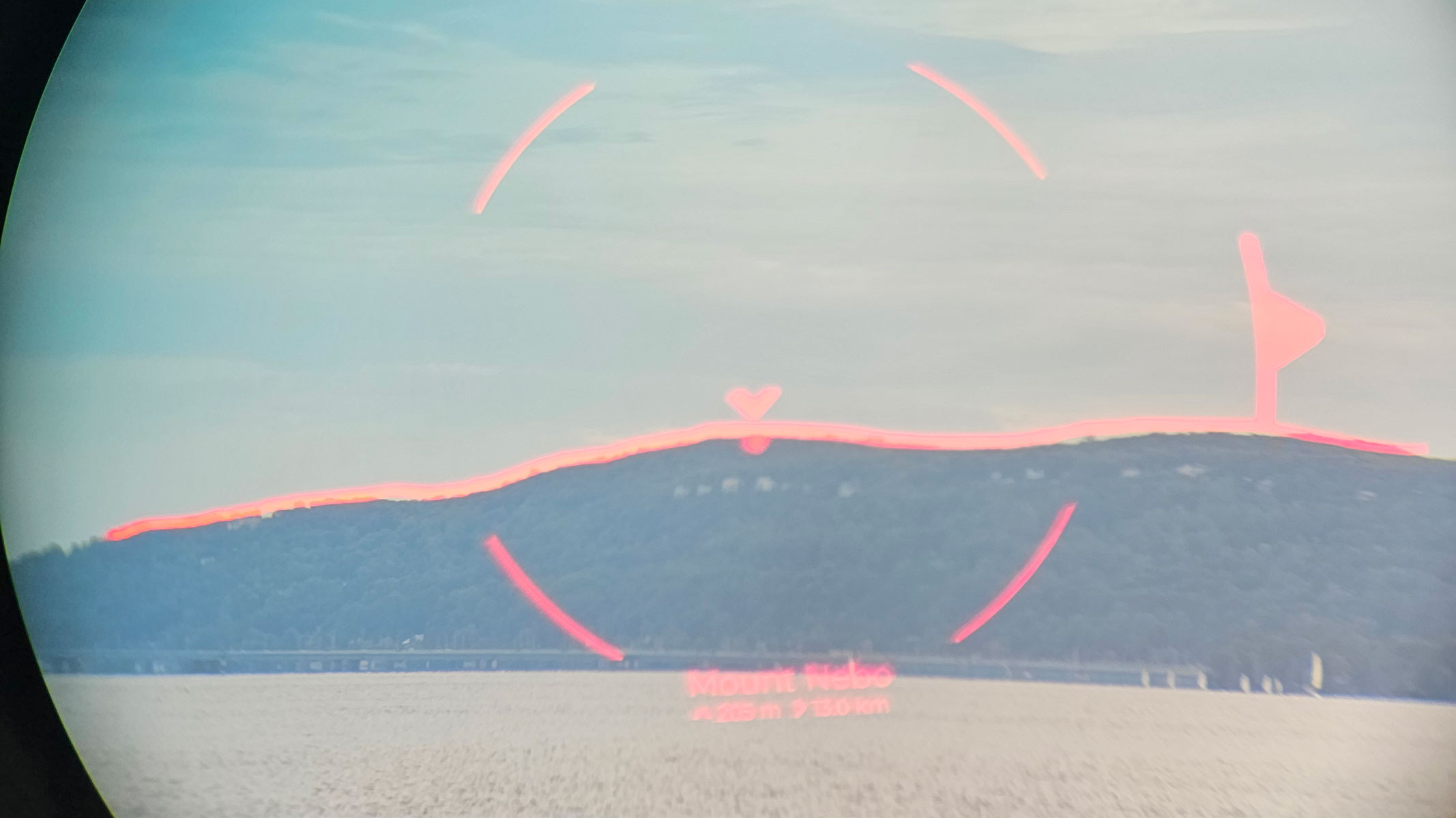 A mountain in the distance with a red AR overlay through binoculars.