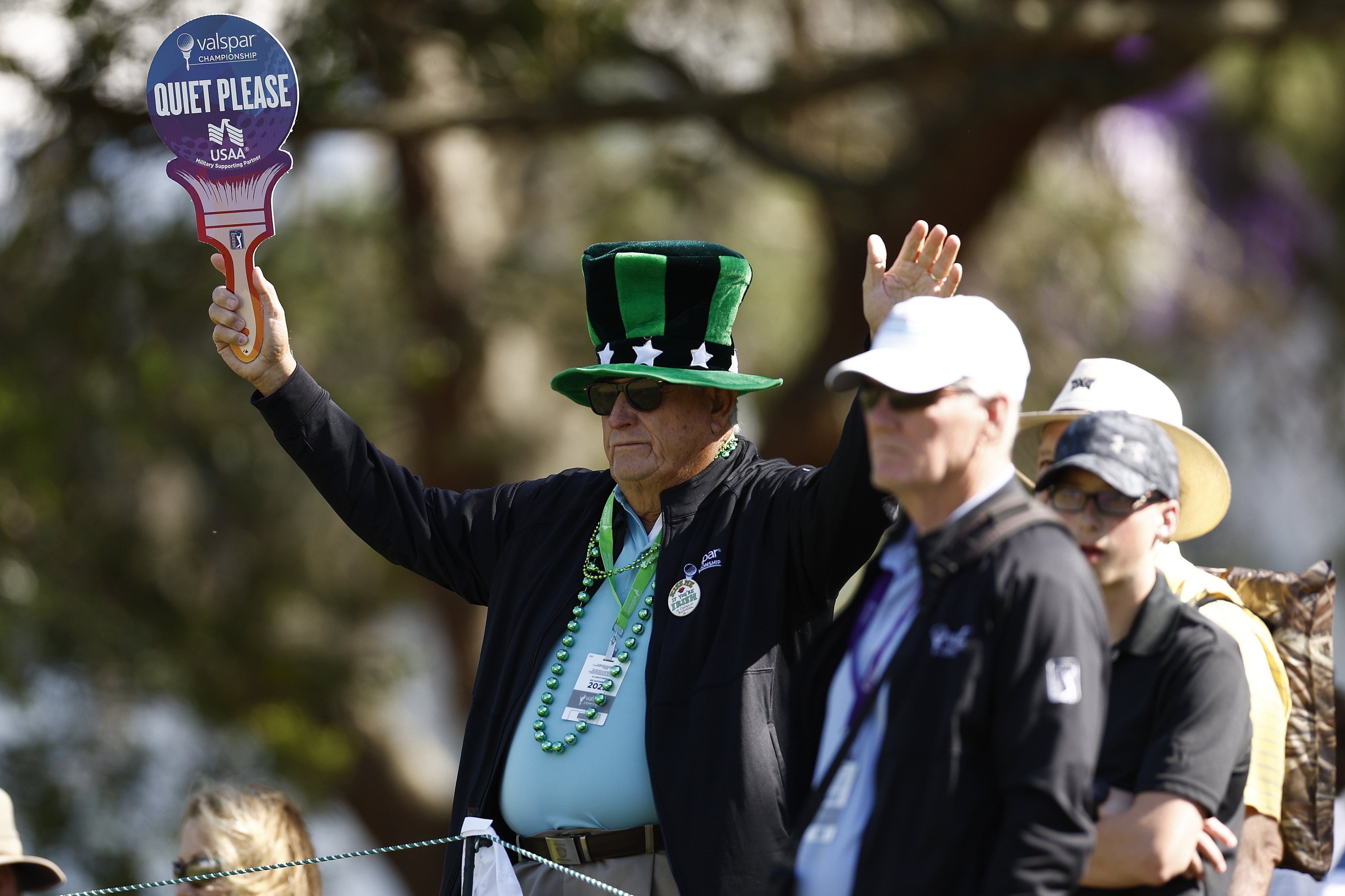 A tournament volunteer holds up a "quiet please" sign at the 2024 Valspar Championship