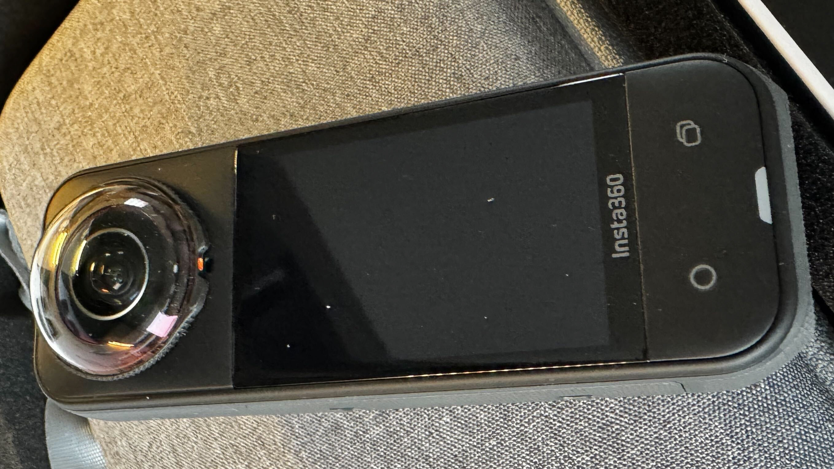 Front view of the Insta360 X5 showing screen and lens details.