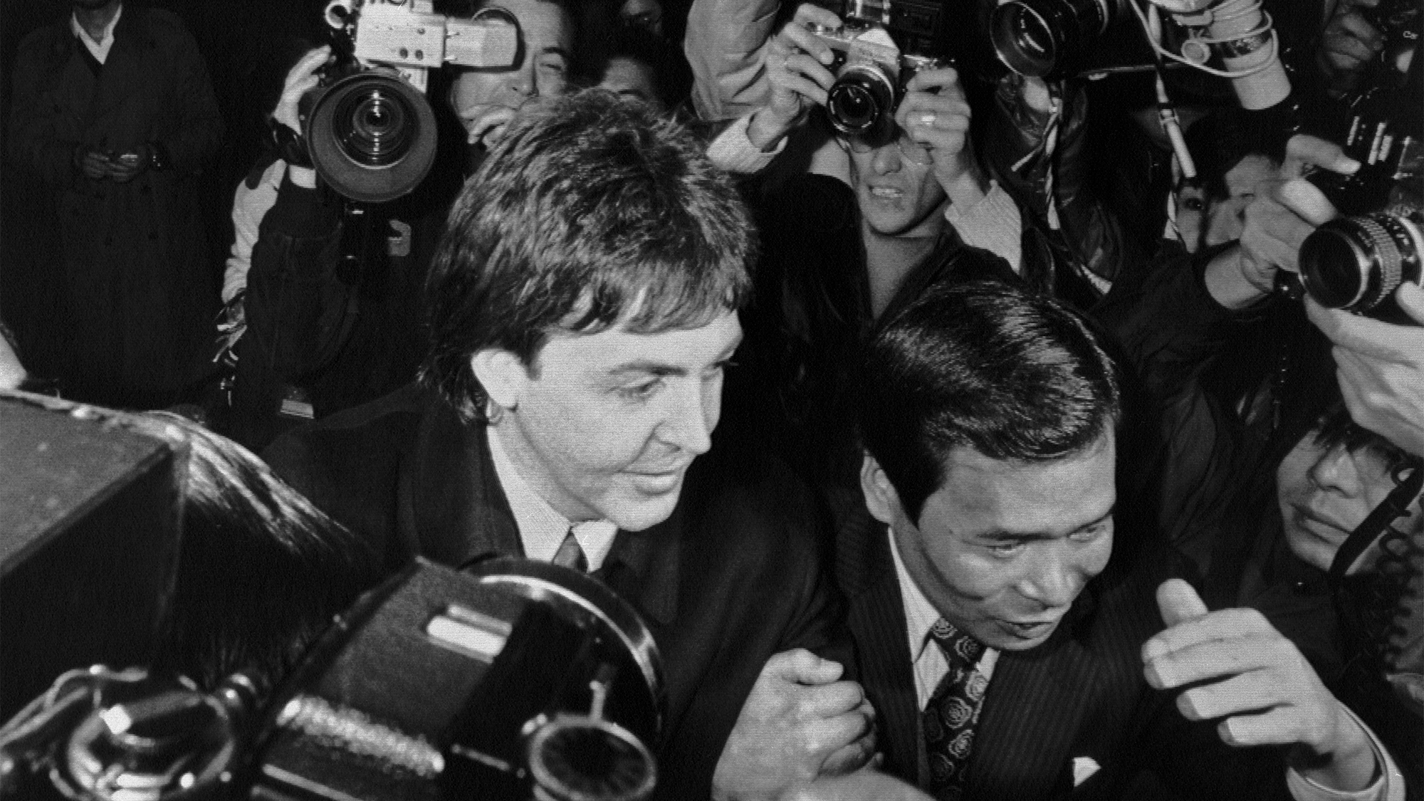 (Original Caption) Surrounded by press photographers, The Wings' leader Paul McCartney enters the narcotics control office of the Health and Welfare Ministry 1/16 after he was arrested for allegedly bringing in over 200 grams of marijuana into Japan, police said.