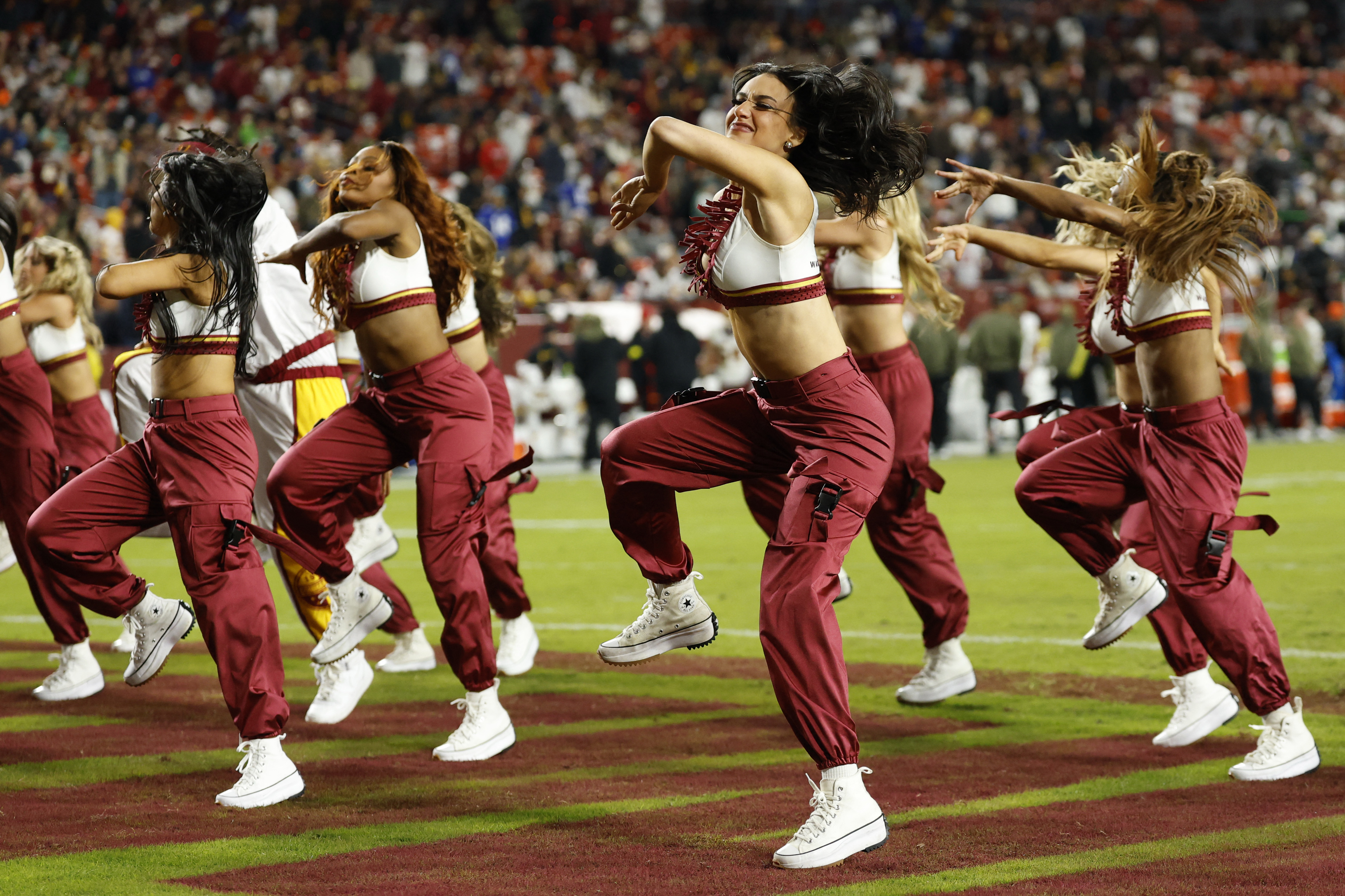 Washington Commanders dancers performing on the field during a game.