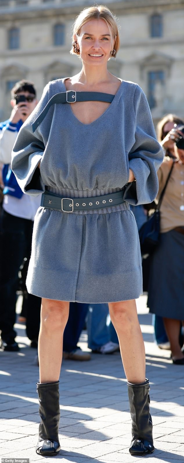 The loose-fitting dress was cinched at the pleated waist with a blue canvas belt and was accented with an unusually placed buckle at the collarbone.
