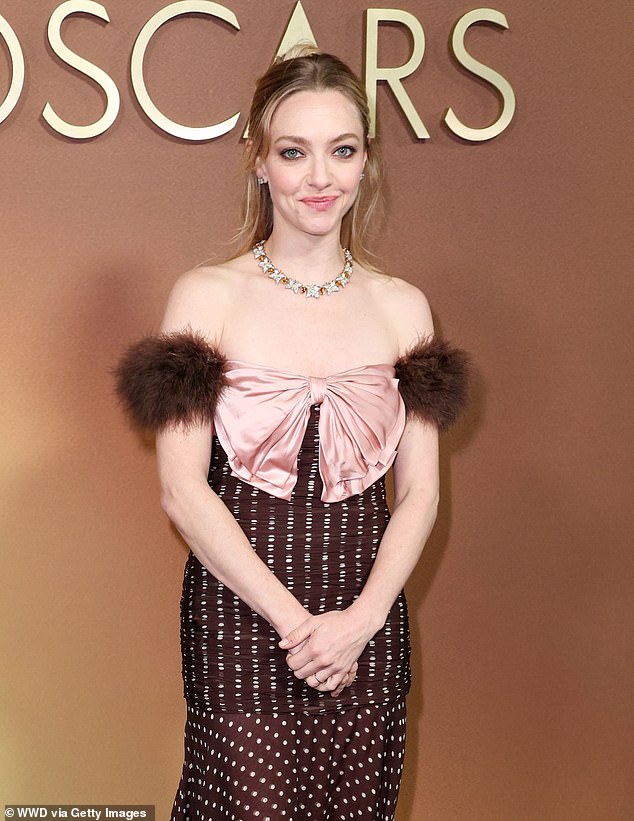 The bizarre frock featured small furry bicep cuffs and a big pink silk bow at the chest