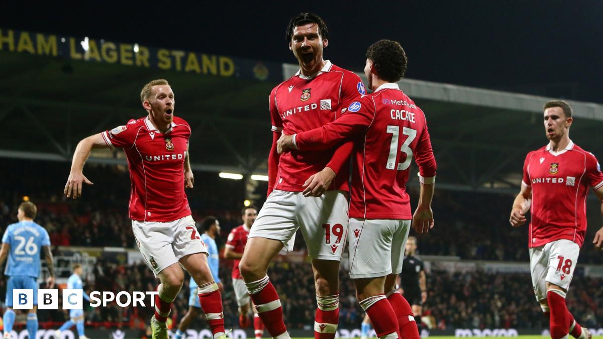 Wrexham striker Kieffer Moore celebrates with Lewis O'Brien and Liberato Cacace
