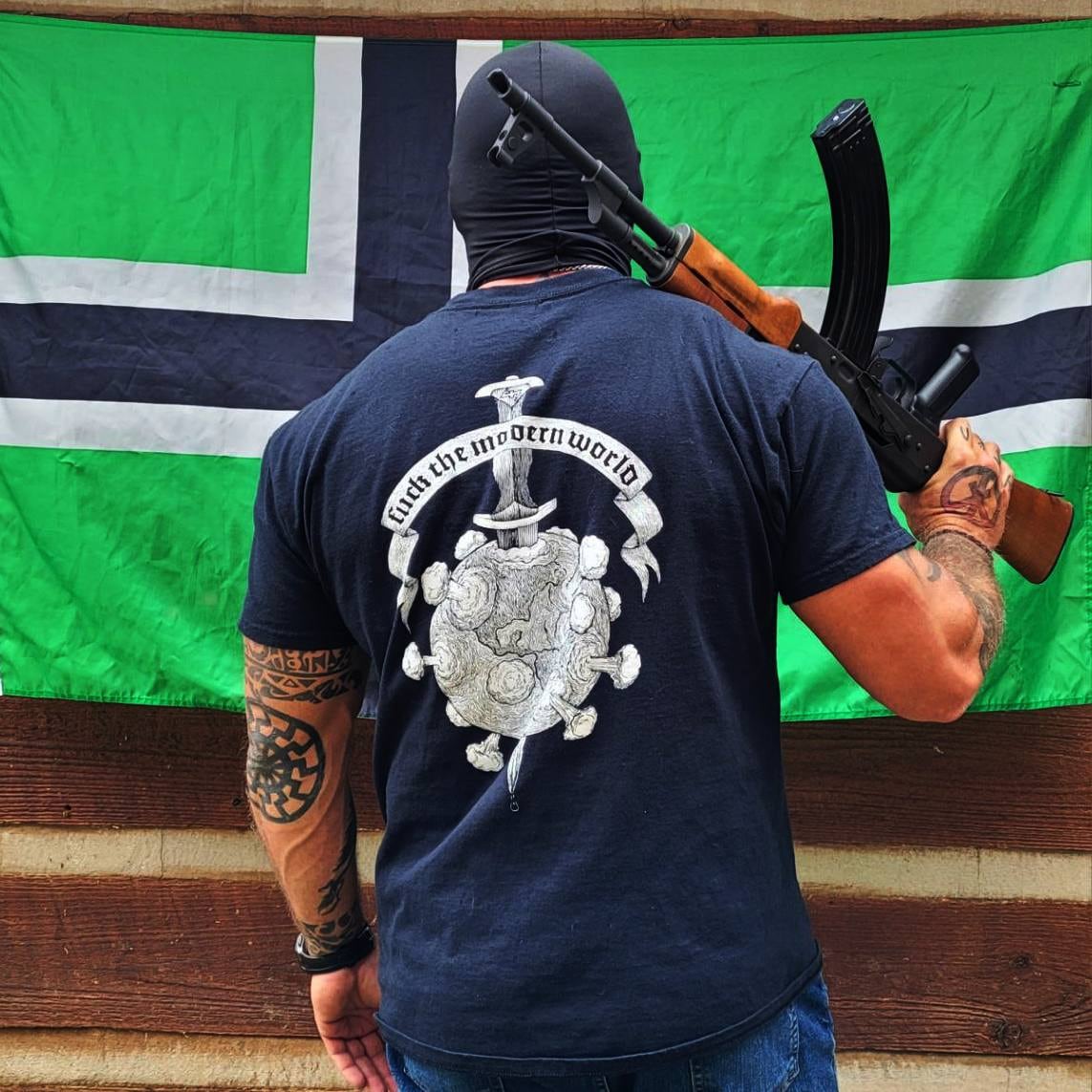 A man carrying a firearm and wearing a shirt from the brand Vinland Battlewear.