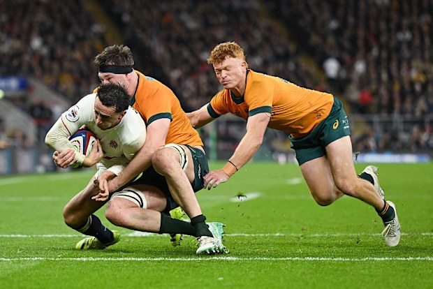 Alex Mitchell of England breaks through the tackles of Nick Frost and Tane Edmed.