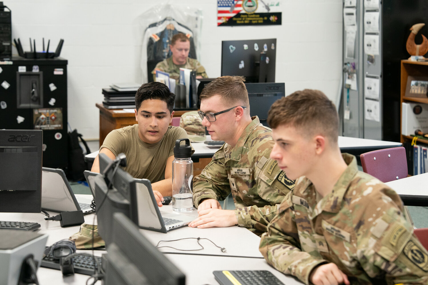 Cadets Daniel Bravo, Eric Shellabarger and Sean Mumm work in the MMA cyber classroom to fulfill the training requirements for their scholarship.