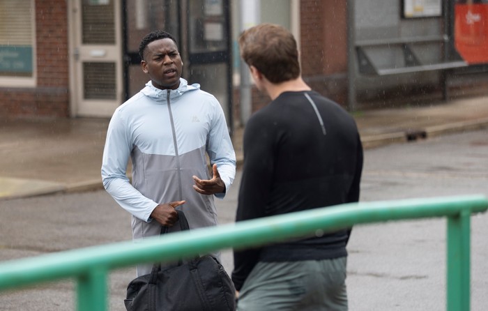 James and Theo chat to one another outside of the medical centre in Coronation Street