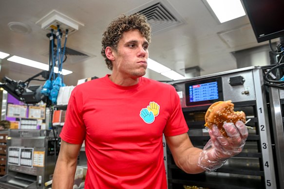 Sydney star Charlie Curnow tests out a burger on McHappy Day on Saturday.