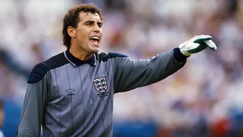 Getty Images Peter Shilton is wearing an England goalkeeper's jersey and goalkeeper gloves during the 1986 World Cup match between Portugal and England.