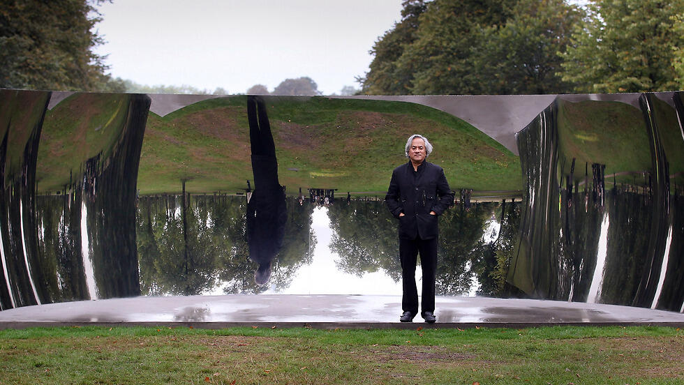 Kapoor standing beside his sculpture C-Curve in Kensington Gardens, London 