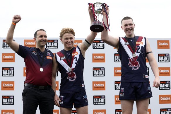 Levi Ashcroft (centre) celebrates Sandringham’s 2024 Talent League flag win with coach Rob Harding (left) and fellow co-captain Brodie Findlay (right).