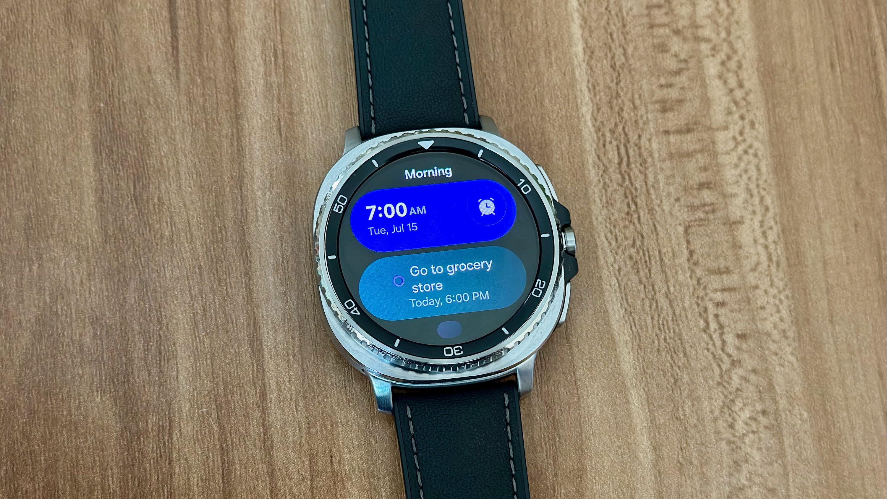 A custom "Morning" Tile on the Samsung Galaxy Watch 8 Classic showing alarm and reminder info