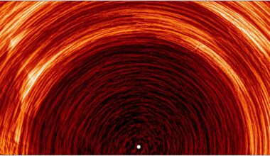 A series of red rings arcing over a white light in the middle of the image