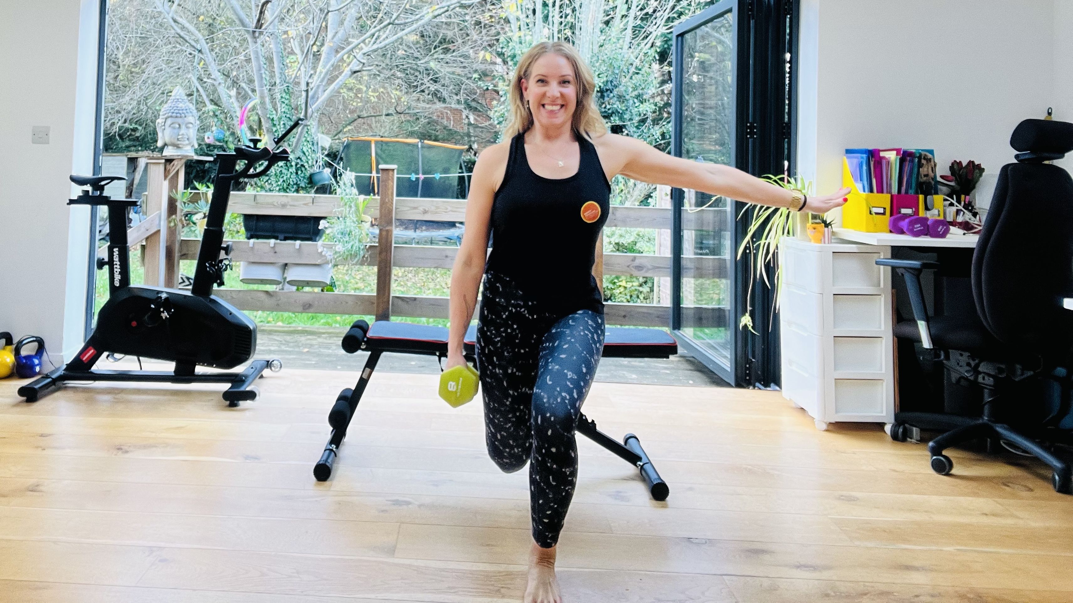 Woman exercising at home using dumbbells and a weight bench