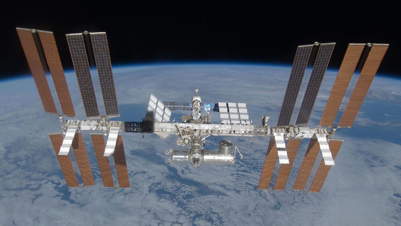 An image of the International Space Station, with its many solar panels and modules, floating above Earth in space