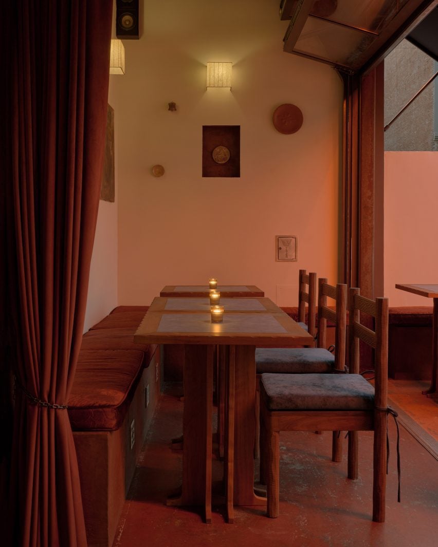 A dining area opened up to an outdoor patio via concertinaed glass panels