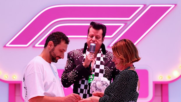 A couple get married by an Elvis impersonator at the wedding chapel set up at the Las Vegas Grand Prix.