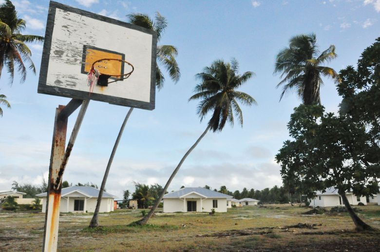 A dilapidated basketball goal is pictured in March 2014 in Rongelap, an atoll of the Marshall Islands that was severely affected by nuclear fallout from the 1954 US hydrogen bomb test on Bikini Atoll. In the back are homes built under a resettlement plan for residents who have evacuated from Bikini.