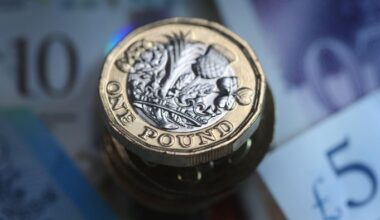 A £1 coin on top of cash