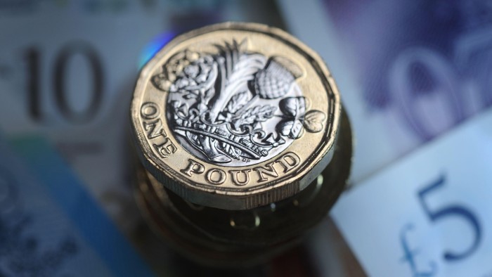 A £1 coin on top of cash