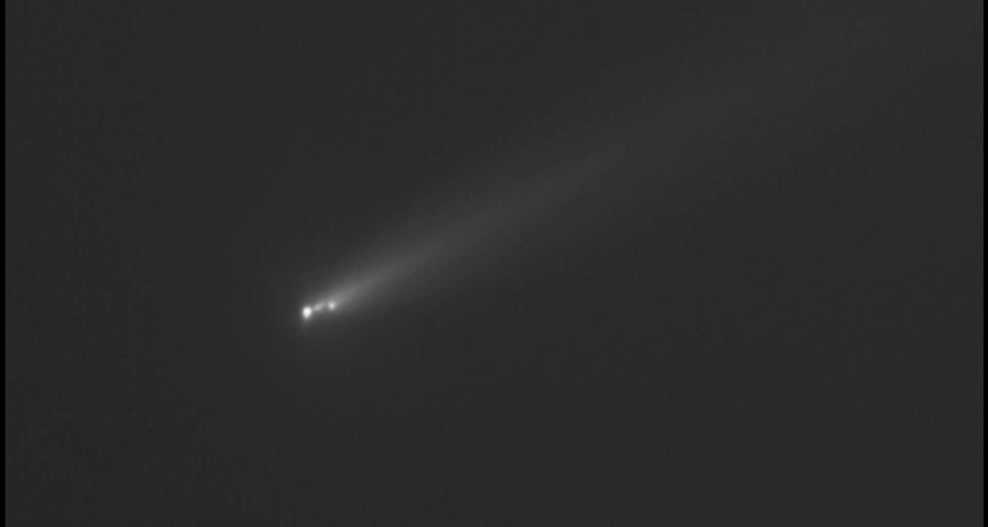 a black and white image of a comet streaking through outer space