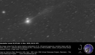 a grayscale image showing a white dot of 3I/ATLAS with a long white tail behind it.