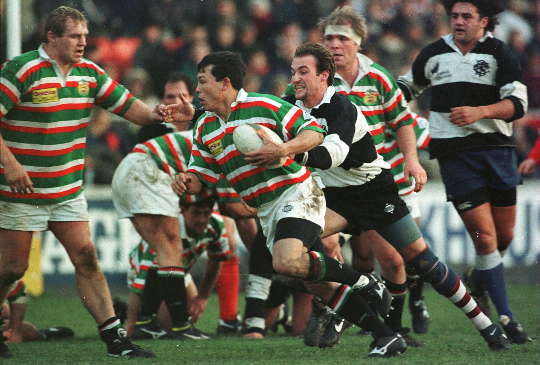 Rory Underwood of Leicester Tigers runs with the ball past Justin Thomas of the Barbarians.