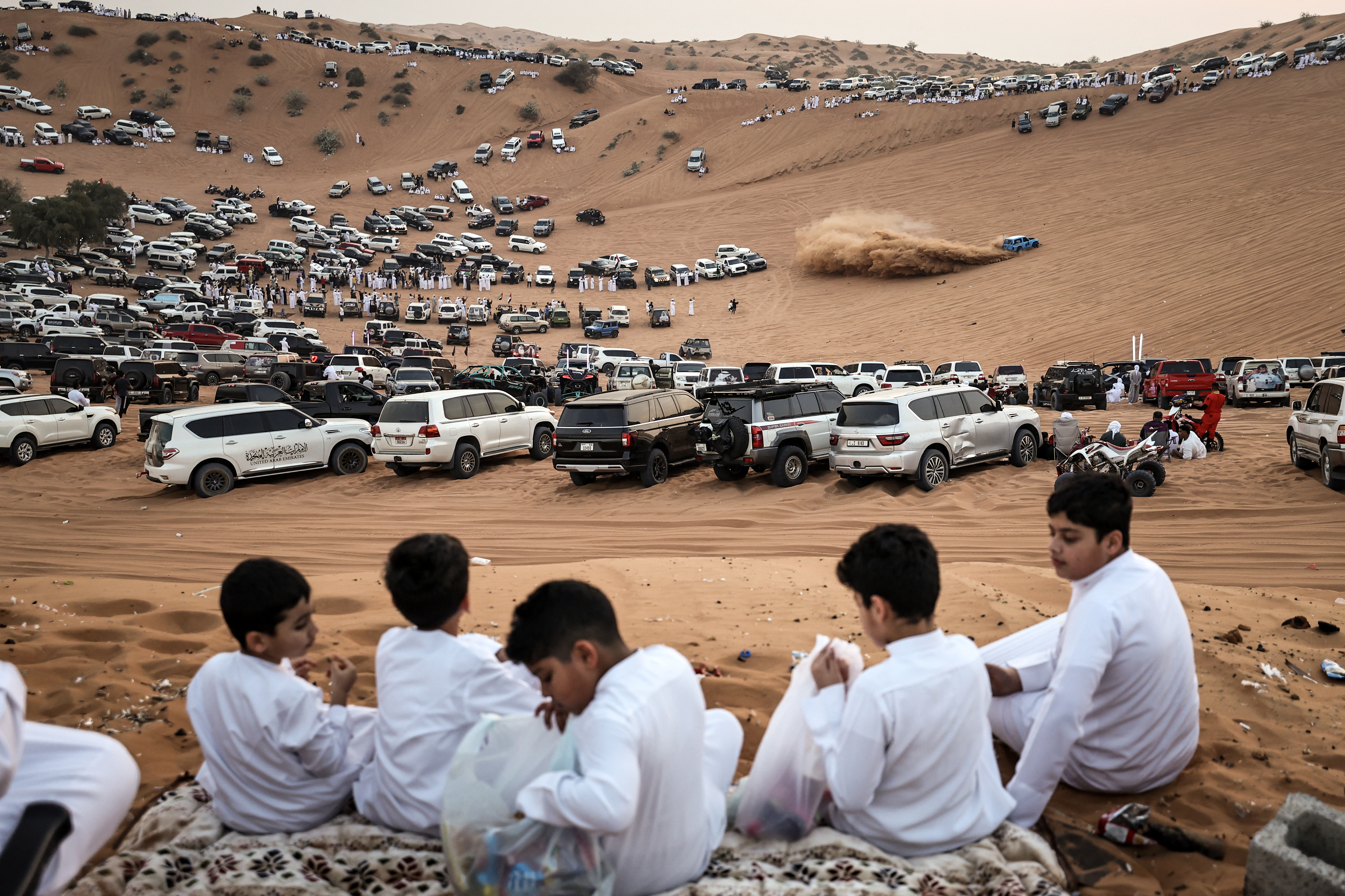 People watch as drifters perform in the desert of Umm Al Quwain.